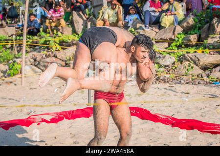 kochi, Indien - 27. Dezember 2023: Kushti-Wrestler schlägt einen anderen während ihres Wettkampfes auf Strandsand Stockfoto
