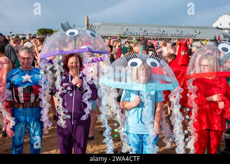 Ramsgate, Großbritannien. Januar 2024. In Ramsgate posieren die Leute mit Regenschirmen, die sich als Quallen ausgeben. 300 Einheimische und Besucher versammelten sich am Main Sands von Ramsgate zum Neujahrsbad. Die Veranstaltung findet aus Wohltätigkeits- und lustigen Gründen statt. 300 Einwohner und Besucher versammelten sich im Main Sands von Ramsgate zum Neujahrsbad, einer Veranstaltung, die für wohltätige Zwecke und Vergnügen durchgeführt wurde. Quelle: SOPA Images Limited/Alamy Live News Stockfoto