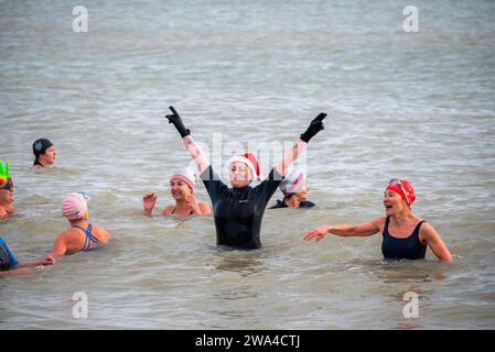 Ramsgate, Großbritannien. Januar 2024. Eine Frau mit einem Weihnachtsmann-Hut genießt das kalte Wasser in Ramsgate. 300 Einheimische und Besucher versammelten sich am Main Sands von Ramsgate zum Neujahrsbad. Die Veranstaltung findet aus Wohltätigkeits- und lustigen Gründen statt. 300 Einwohner und Besucher versammelten sich im Main Sands von Ramsgate zum Neujahrsbad, einer Veranstaltung, die für wohltätige Zwecke und Vergnügen durchgeführt wurde. Quelle: SOPA Images Limited/Alamy Live News Stockfoto