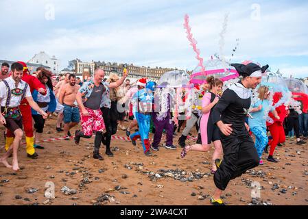 Ramsgate, Großbritannien. Januar 2024. In Kostümen gekleidete Leute laufen zum Neujahrsfest in Ramsgate ins Wasser. 300 Einheimische und Besucher versammelten sich am Main Sands von Ramsgate zum Neujahrsbad. Die Veranstaltung findet aus Wohltätigkeits- und lustigen Gründen statt. 300 Einwohner und Besucher versammelten sich im Main Sands von Ramsgate zum Neujahrsbad, einer Veranstaltung, die für wohltätige Zwecke und Vergnügen durchgeführt wurde. Quelle: SOPA Images Limited/Alamy Live News Stockfoto