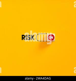 Risiko auf Schieberegler auf gelbem Hintergrund. Risikobereitschaft oder Risikomanagement im Unternehmen. Stockfoto