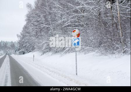 Schilder mit Geschwindigkeitsbegrenzung und Radarkamera im Schnee Stockfoto