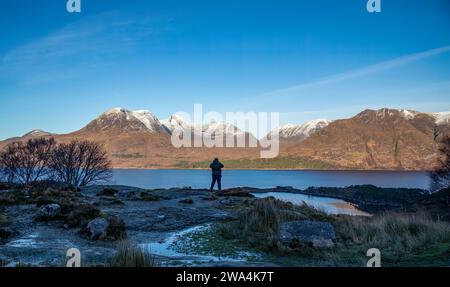 Ein Mann fotografiert die schottischen Berge in Torridon, Beinn Alligin und Liathach Stockfoto