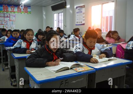 Haidong, chinesische Provinz Qinghai. Januar 2024. Die Schüler besuchen eine Klasse an der Zentralschule in Guanting Township in Minhe Hui und Tu Autonomous County, Stadt Haidong, nordwestchinesische Provinz Qinghai, 2. Januar 2024. Die vom Erdbeben betroffenen Grund- und Sekundarschulen in Qinghai nahmen am Dienstag den Offline-Unterricht wieder auf. Quelle: Zhang Long/Xinhua/Alamy Live News Stockfoto