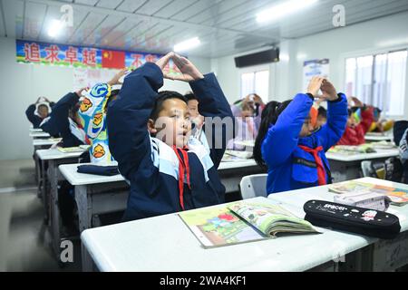 Haidong, chinesische Provinz Qinghai. Januar 2024. Die Schüler singen vor dem Unterricht an der Zentralschule in Guanting Township in Minhe Hui und Tu Autonomous County, Stadt Haidong, nordwestchinesische Provinz Qinghai, 2. Januar 2024. Die vom Erdbeben betroffenen Grund- und Sekundarschulen in Qinghai nahmen am Dienstag den Offline-Unterricht wieder auf. Quelle: Zhang Long/Xinhua/Alamy Live News Stockfoto