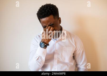 Porträt eines jungen Geschäftsmannes, der müde ist und Kopfschmerzen hat. Stockfoto