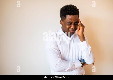 Porträt eines jungen Geschäftsmannes, der müde ist und Kopfschmerzen hat. Stockfoto