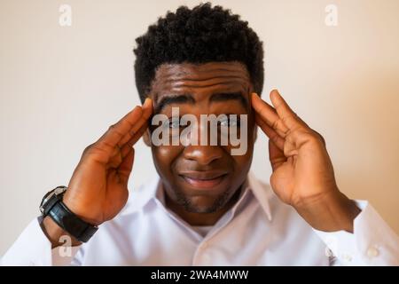 Porträt eines jungen Geschäftsmannes, der müde ist und Kopfschmerzen hat. Stockfoto