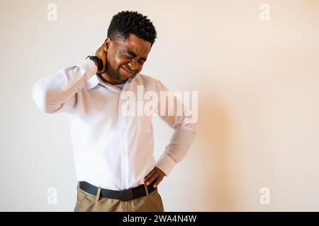 Porträt eines jungen Geschäftsmannes, der Schmerzen im Nacken hat. Kopieren Sie einen Platz auf dem Bild für Ihren Text oder Ihre Werbung. Stockfoto