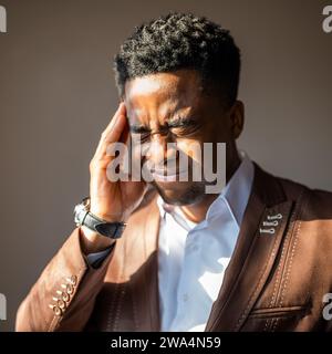 Porträt eines jungen Geschäftsmannes, der müde ist und Kopfschmerzen hat. Stockfoto