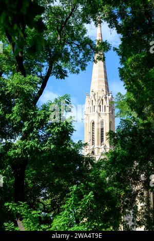 Der Kirchturm von Szent Erzsébet / St. Elisabeth Pfarrkirche auf Rozsak tere im Bezirk VII, durch das Laub von Bäumen gesehen, Budapest, Ungarn von Imre Stei Stockfoto