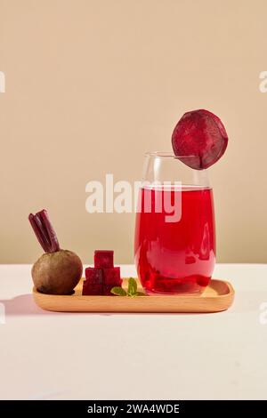 Auf dem braunen Hintergrund, eine Glasschale Rote Bete Saft mit einigen Rote Bete Scheiben auf Holztablett. Rote-Bete-Saft kann verschiedene biologische Aktivi haben Stockfoto