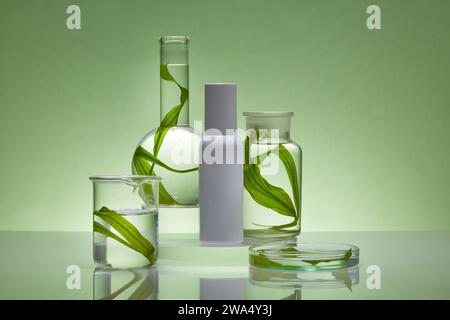 Mockup-Szene zur Kosmetik von Algenextrakt mit Laborkonzept. Weiße Flasche ohne Etikett auf transparentem Podium, frische Algenblätter auf Glas Stockfoto
