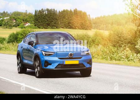 Blauer Volvo XC40 Laden Sie das Elektroauto an einem sonnigen Sommertag mit hoher Geschwindigkeit auf der Autobahn auf. Salo, Finnland. August 2023. Stockfoto