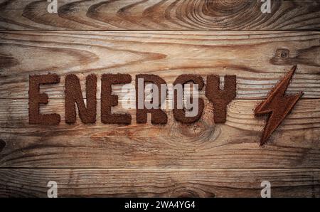 Das Wort Energie geschrieben von gemahlenem Kaffee auf einem alten Hintergrund aus Holz Stockfoto