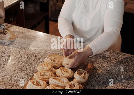 Eine Hausfrau, die hausgemachte Tagliatelle-Pasta zubereitet Stockfoto