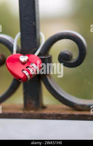 Lovelock rotes Herz mit silbernem Kombinationsschloss, eingestellt auf Glückszahl 777 Nahaufnahme vertikaler Schuss verschwommener Hintergrund Stockfoto