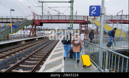 Bad Vilbel, Deutschland. Januar 2024. Eine Gruppe von Reisenden beginnt ihre Rückfahrt, nachdem sie erkannt hat, dass keine Züge fahren. Vom 2. Januar bis 18. Februar werden keine Züge auf dieser Strecke verkehren, bevor der komplett sanierte Abschnitt zwischen Frankfurt West und Bad Vilbel endlich in Betrieb genommen wird. Es wurde ein Ersatz-Bus-Service eingerichtet. Die Bahnstrecke wurde seit 2017 von zwei auf vier Gleise erweitert, von denen zwei dann nur noch von S-Bahn-Zügen genutzt werden. Damit soll ein Engpass im Schienennetz beseitigt werden. Darlegung: Andreas Arnold/dpa/Alamy Live News Stockfoto