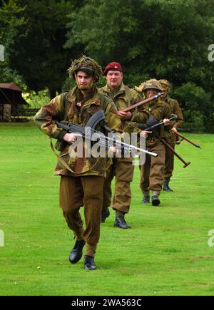 Nachstellung der Gruppe von vier Männern in britischen Uniformen des Zweiten Weltkriegs mit Handwaffen. Stockfoto