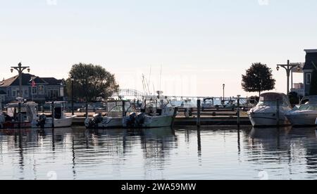 Babylon, New York, USA - 7. September 2021: Eine Gruppe von Booten parkte an einem Dock mit der Great South Bay Bridge im Hintergrund auf Long Island. Stockfoto