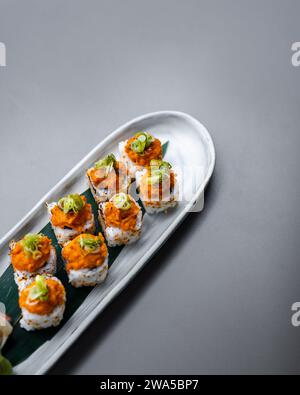 japanisches Sushi. Maki und Brötchen mit Thunfisch, Lachs, Garnelen, Krabben und Avocado. Rainbow Sushi Roll, Uramaki, Hosomaki und Nigiri. Stockfoto