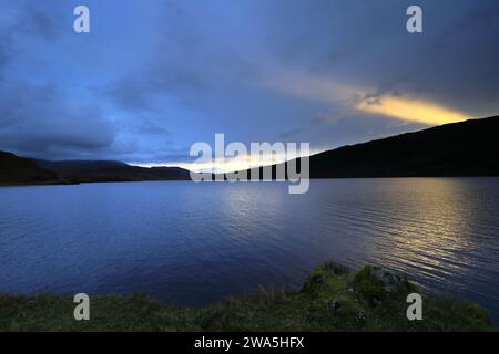 Blick auf den Sonnenuntergang über Loch Assynt, Sutherland, Nordwesten Schottlands, Großbritannien Stockfoto