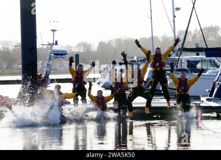 Helensburgh Lifeboat Crew beim New Year Dook in Rhu Marina, Schottland Stockfoto