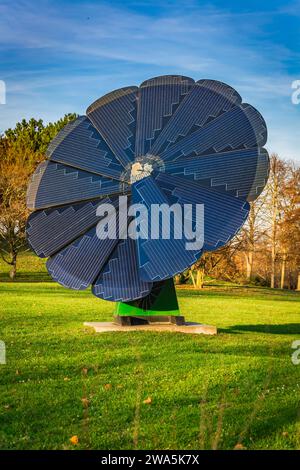 Rotierendes Solarmodul in Blütenform im Stadtpark. Photovoltaik, alternative Stromquelle Stockfoto