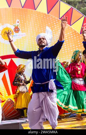 Porträt von männlichen Künstlern aus haryana, während sie den Volkstanz von haryana in ethnischer Kleidung und Turban auf der Surajkund Craft Fair aufführen. Stockfoto