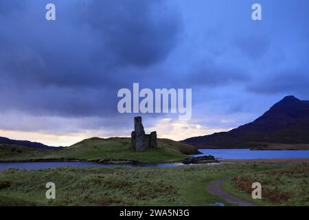 Blick auf den Sonnenuntergang über Ardvreck Castle am Loch Assynt, Sutherland, Nordwesten Schottlands, Großbritannien Stockfoto