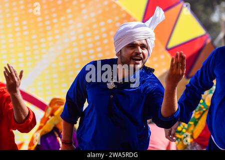 Porträt von männlichen Künstlern aus haryana, während sie den Volkstanz von haryana in ethnischer Kleidung und Turban auf der Surajkund Craft Fair aufführen. Stockfoto