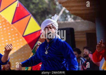 Porträt von männlichen Künstlern aus haryana, während sie den Volkstanz von haryana in ethnischer Kleidung und Turban auf der Surajkund Craft Fair aufführen. Stockfoto