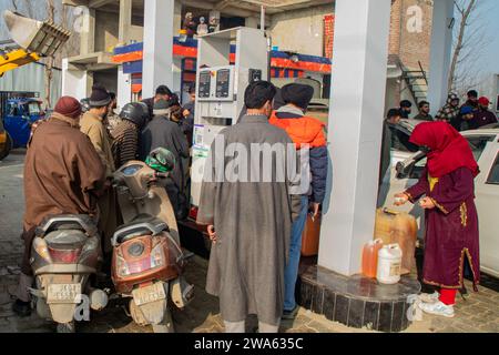 Srinagar, Indien. Januar 2024. Die Leute warten in einer Warteschlange, um an einer Tankstelle Tankdosen aufzufüllen. Tankstellen in verschiedenen indischen bundesstaaten sind Zeugen langer Warteschlangen, als Folge ständiger Proteste von Lkw- und Busfahrern im ganzen Land gegen das neue Panelgesetz über Trefferfälle. Das neu eingeführte Gesetz von Bharatiya Nyaya Sanhita, das das indische Strafgesetzbuch aus der britischen Ära aufhob, verhängt eine zehnjährige Haftstrafe und eine Geldstrafe von 184,76 US-Dollar, weil sie einem Unfallort entkommen und den Vorfall nicht gemeldet haben. (Foto: Faisal Bashir/SOPA Images/SIPA USA) Credit: SIPA USA/Alamy Live News Stockfoto