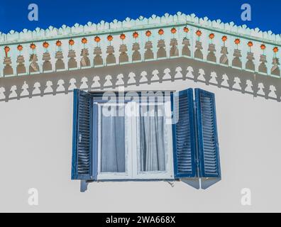 Fenster im griechischen Stil, blau-weiße Fenster in einem wunderschönen kleinen Haus mit blauem Himmel. Fenster im traditionellen griechischen Stil. Reisekonzept Stockfoto