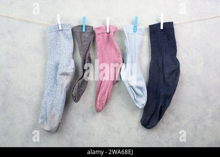 Verlorene Socken hängen an einer Wäscheleine mit Kleiderschrank, fehlende Socken nach dem Waschen, Gedenktag Stockfoto