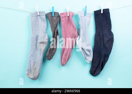 Verlorene Socken hängen an einer Wäscheleine mit Kleiderschrank, fehlende Socken nach dem Waschen, Gedenktag Stockfoto