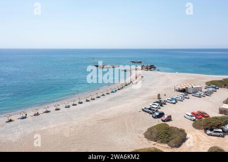 Palaiochora Stadt, Kreta Griechenland, Kiesstrand mit Sonnenschirm. Drohnenblick aus der Luft auf transparentes kristallklares Meerwasser, blauer Himmel, schwimmende Menschen. Stockfoto