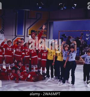 1, 2 oder 3, ZDF Quizshow für Kinder, moderiert von Michel Schanze, auf dem Bild mit Eishockey Junioren, Deutschland, 1983. Deutschland, 1981. 1, 2 oder 3, TV-Quizshow für Kinder, präsentiert von Michael Schanze, auf dem Foto mit Eishockey Junior, Deutschland, 1983. Stockfoto