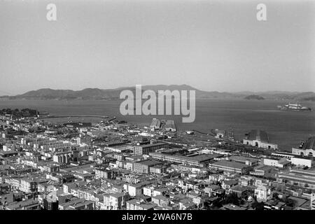 Blick über die Bucht von San Francisco und Fishermen's Wharf, links außen die Golden Gate Brücke und rechts außen Alcatraz Island vom Coit Aussichtsturm auf dem Telegraph Hill aus, 1962. Blick auf die San Francisco Bay und die Fishermen's Wharf, mit der Golden Gate Bridge ganz links und Alcatraz Island ganz rechts vom Coit Aussichtsturm auf Telegraph Hill, 1962. Stockfoto