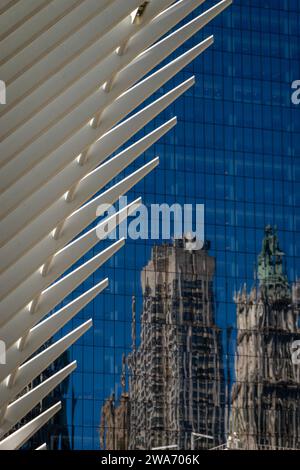 Flügel des Oculus-Gebäudes neben einem Spiegelbild des alten Gebäudes in einem modernen blauen Glasgebäude in Downtown Manhattan NYC Stockfoto