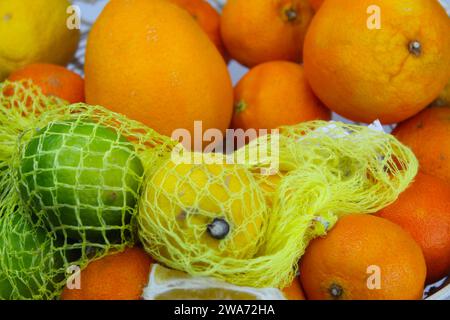 Ein Nahfoto einer Schüssel Zitronen, Orangen und Limetten. Stockfoto