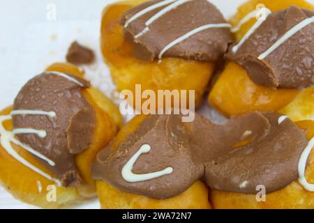 Ein Nahfoto von Schokoladen-Profiterolen in einer Plastikkiste. Stockfoto