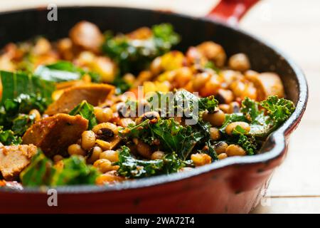 Hoppin' John- Schwarzaugenerbsen mit veganen Würsten in einer gusseisernen Pfanne. Stockfoto