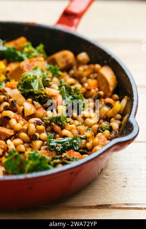 Hoppin' John- Schwarzaugenerbsen mit veganen Würsten in einer gusseisernen Pfanne. Stockfoto