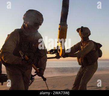 US-Streitkräfte. 151029WC184-007 PINHEIRO da CRUZ, PRAIA da RAPOSA, Portugal – U.S. Marine Lance CPL. Micah English, ein Experte für die Unterstützung der Landung, mit der Landung Support Detachment, 26. Marine Expeditionary Unit an Bord des amphibischen Transportdocks USS Arlington (LPD 24) läuft unter einem CH-53E Super Hengst mit Marine Medium Tilt Rotor Squadron 162 (VMM-162), 26. MEU, an Bord der USS Arlington, schwebend über dem Kopf, während James Stamper, ein Landeunterstützungsspezialist, die angeschlossene Schlinge während einer externen Liftübung A hält Stockfoto