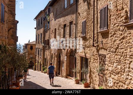 Eine Person, die auf einer malerischen Gasse im Zentrum von Volterra, Italien, spaziert Stockfoto