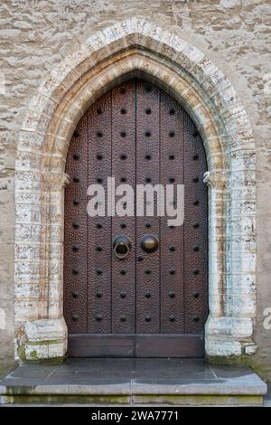 Alte Tür an einer alten mittelalterlichen Steinfassade in der alten Stadt Tallinn, Estland. Stockfoto
