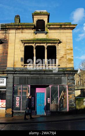 Neben dem Rochdale-Kanal in der Yorkshire Town of Todmorden steht ein stillgelegter und verlassener Laden mit allen Fenstern aus dem ersten Stock. Stockfoto