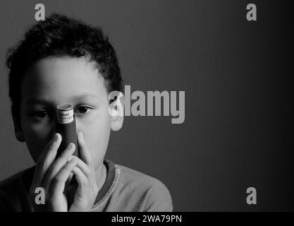 Kind mit Grippe mit Inhalator Atemschutz auf grauem Hintergrund mit Menschen Stockfoto Stockfoto