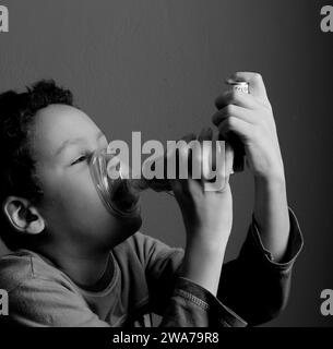 Kind mit Grippe mit Inhalator Atemschutz auf grauem Hintergrund mit Menschen Stockfoto Stockfoto